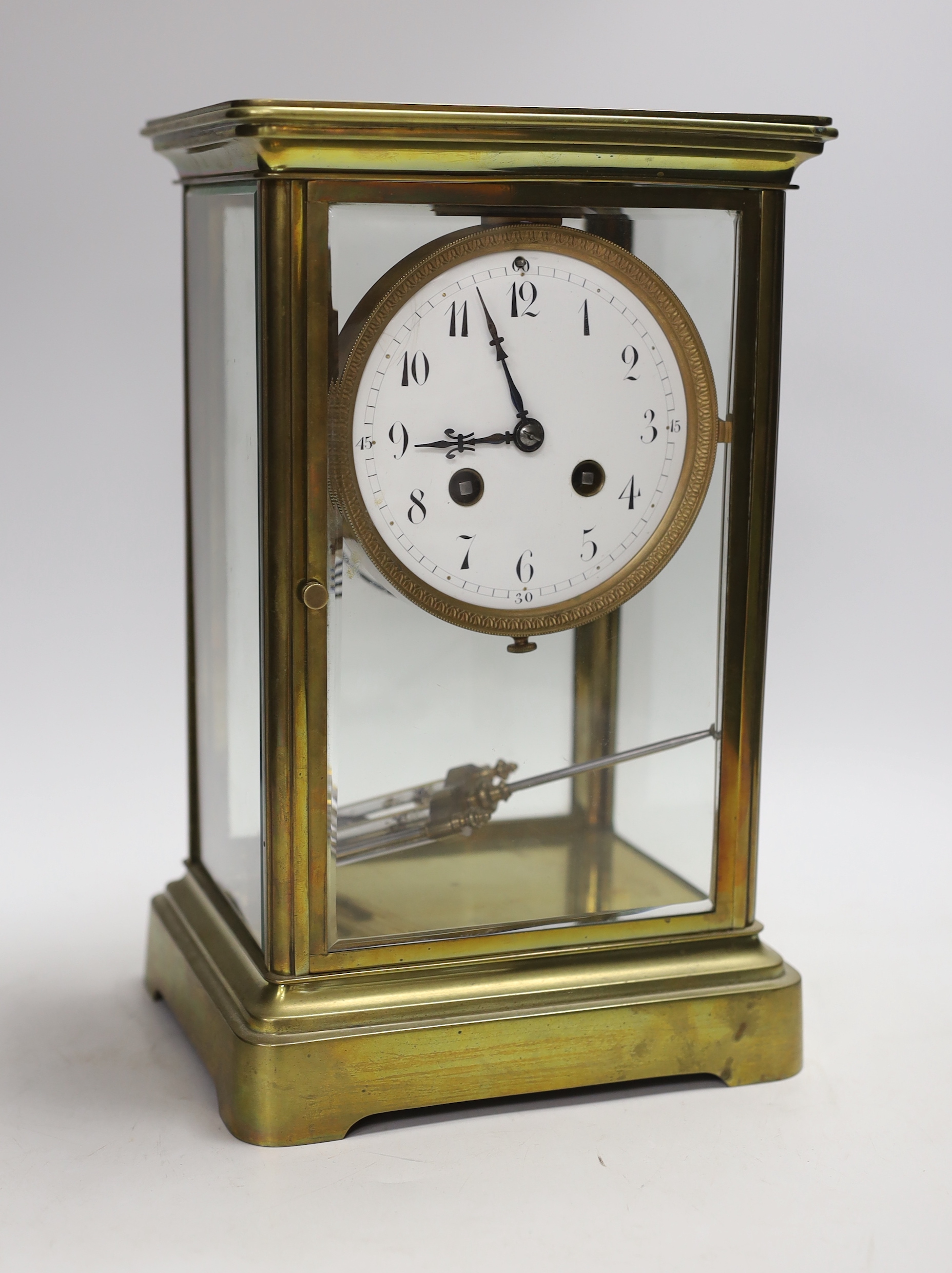 An early 20th century brass four glass clock with mercury pendulum, 28cm high